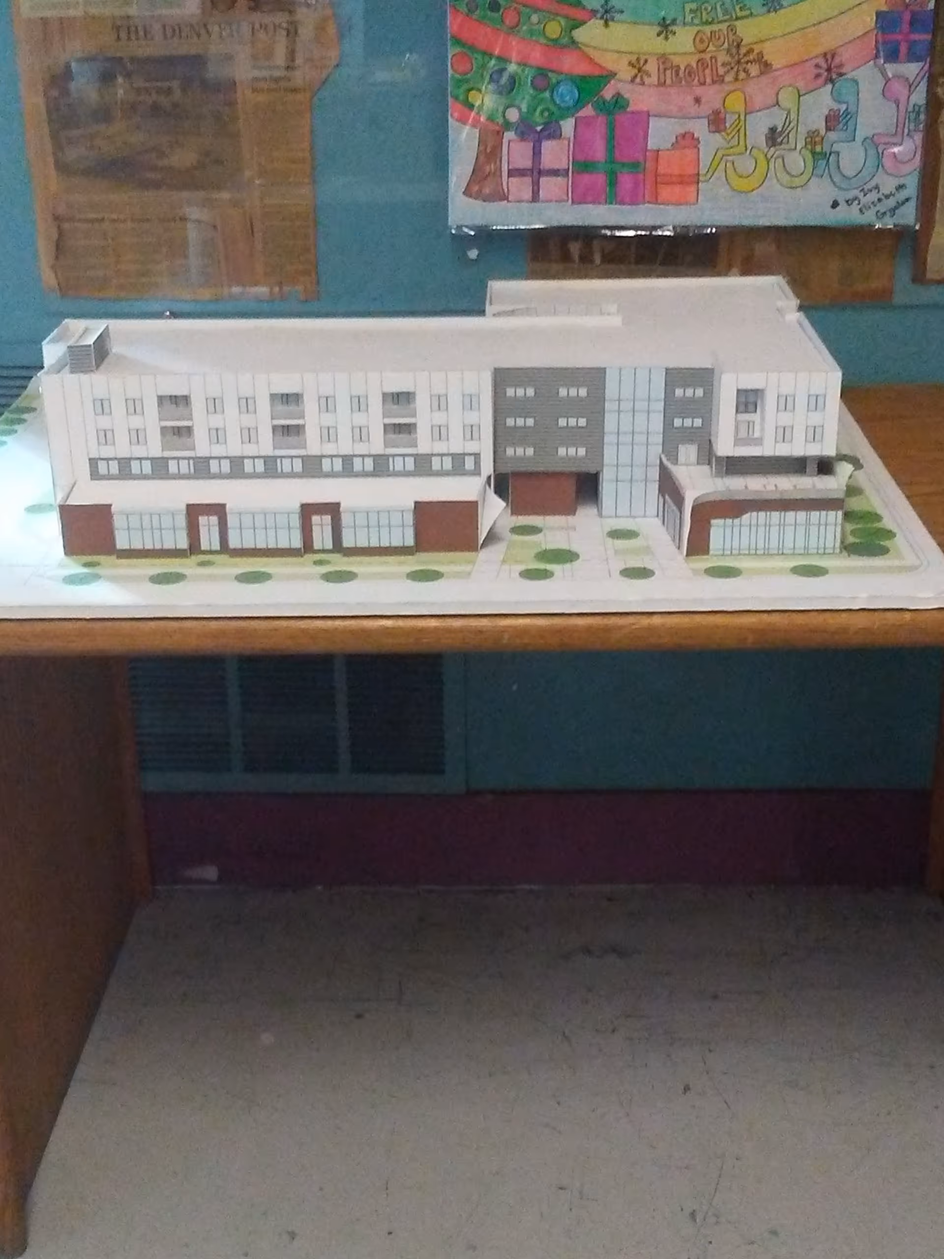 Scale architectural model of Atlantis Community, Inc. building on a table.