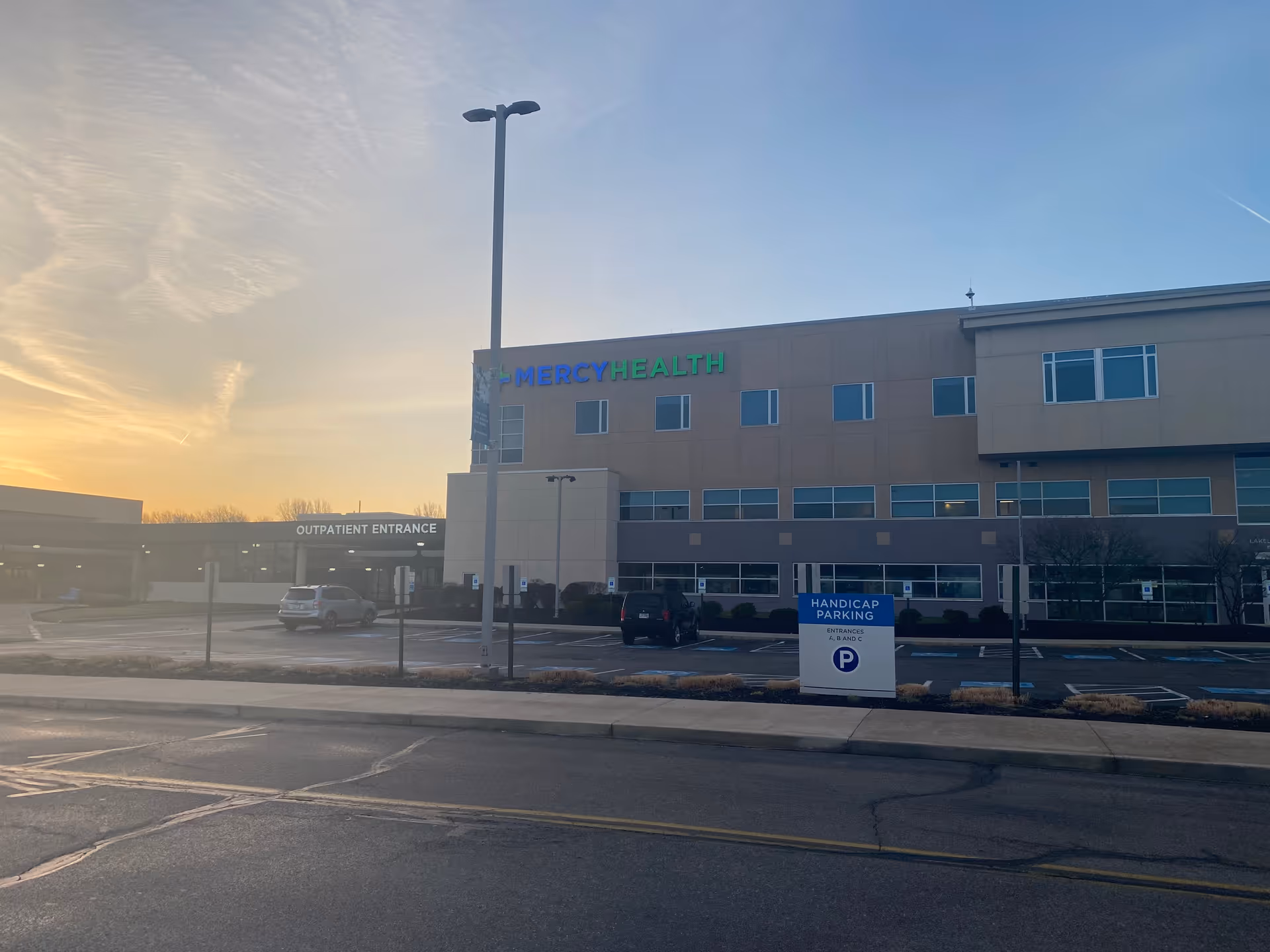 Exterior view of Mercy Health - Lorain Hospital with parking lot.