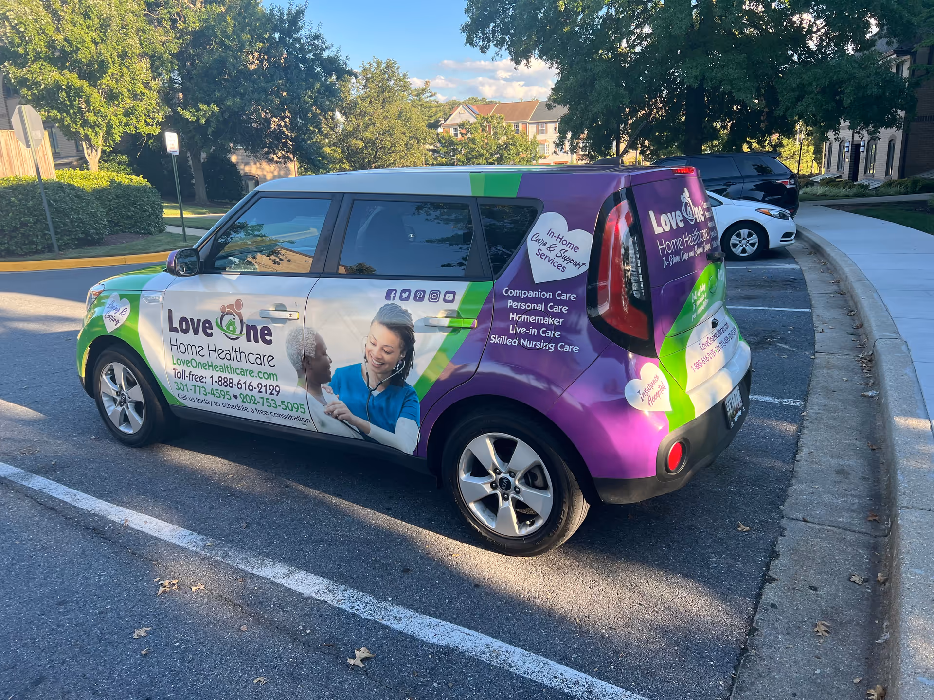 Colorful Love One Home Healthcare van parked in a residential parking lot.