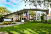 Front view of Palo Alto Sub-acute and Rehabilitation Center with lawn and flag.