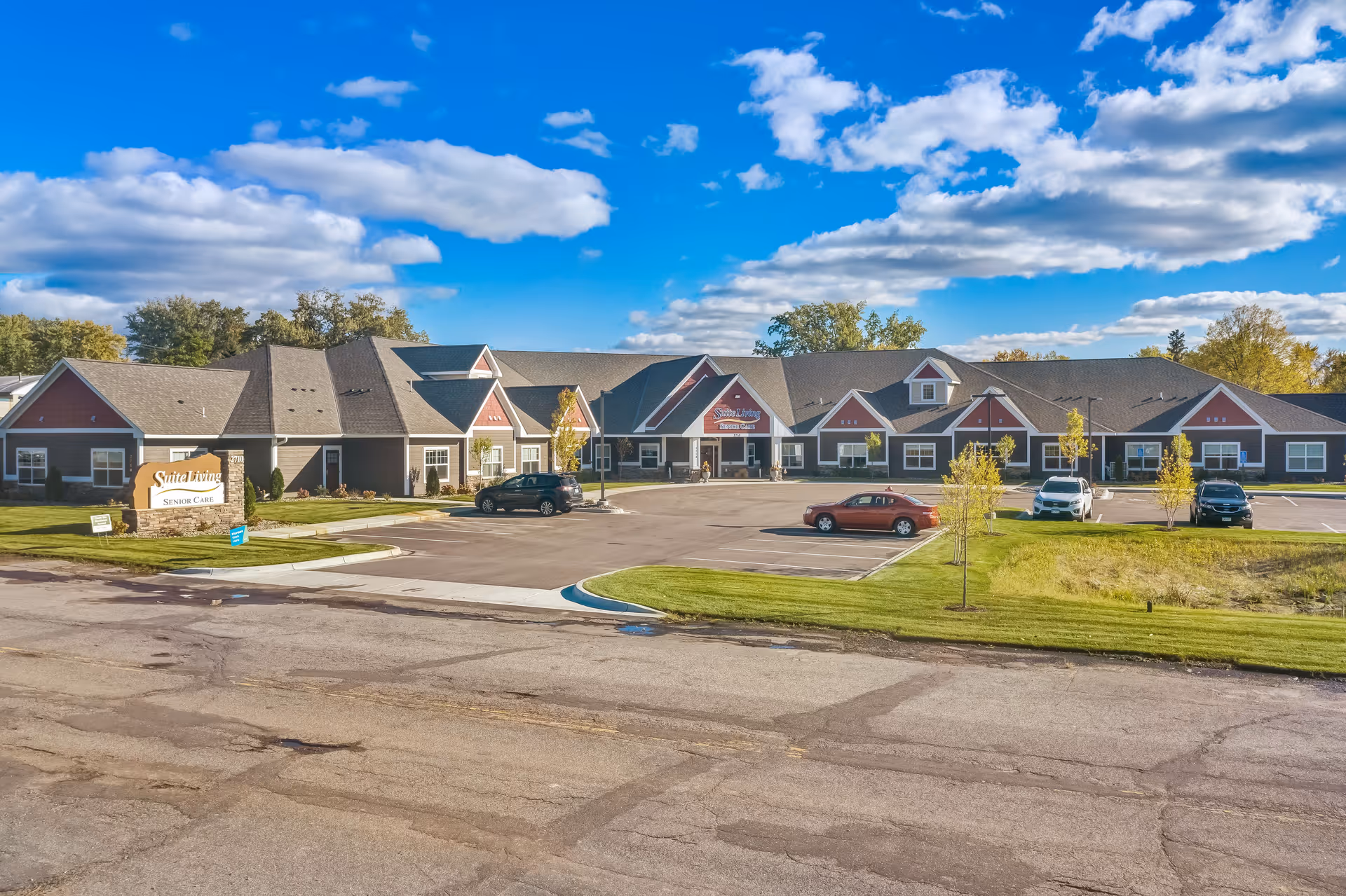 Exterior view of Suite Living Senior Care facility front with parking and blue sky