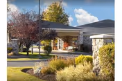 Exterior view of Life Care Center entrance with landscaped grounds and blue sky.