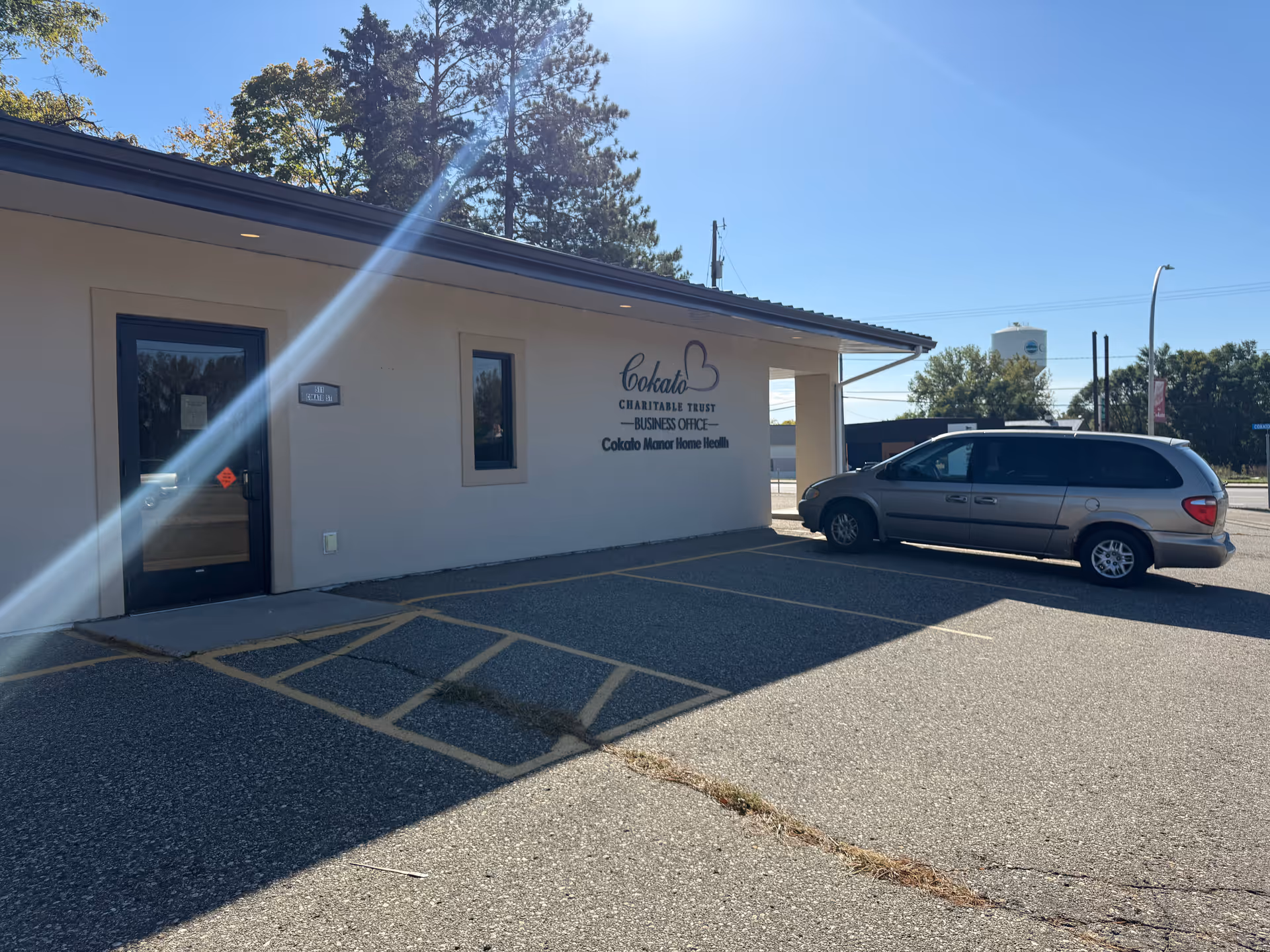 Exterior view of Cokato Manor building with sign and a parked silver minivan.