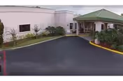 Exterior view of Highlands Lake Center with a driveway, entrance canopy, and landscaped area.