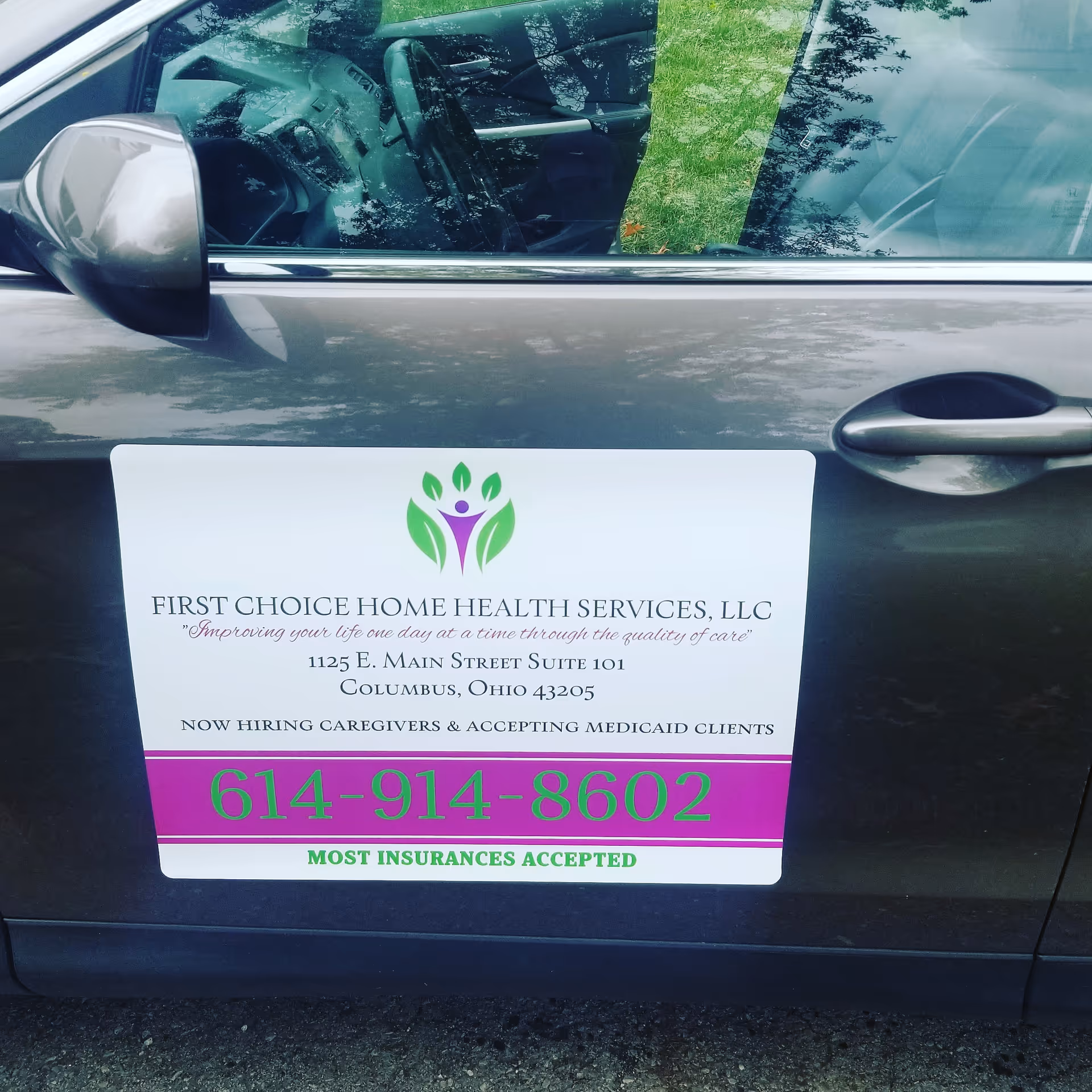 Vehicle door with a sign for First Choice Home Health Services advertising contact info.