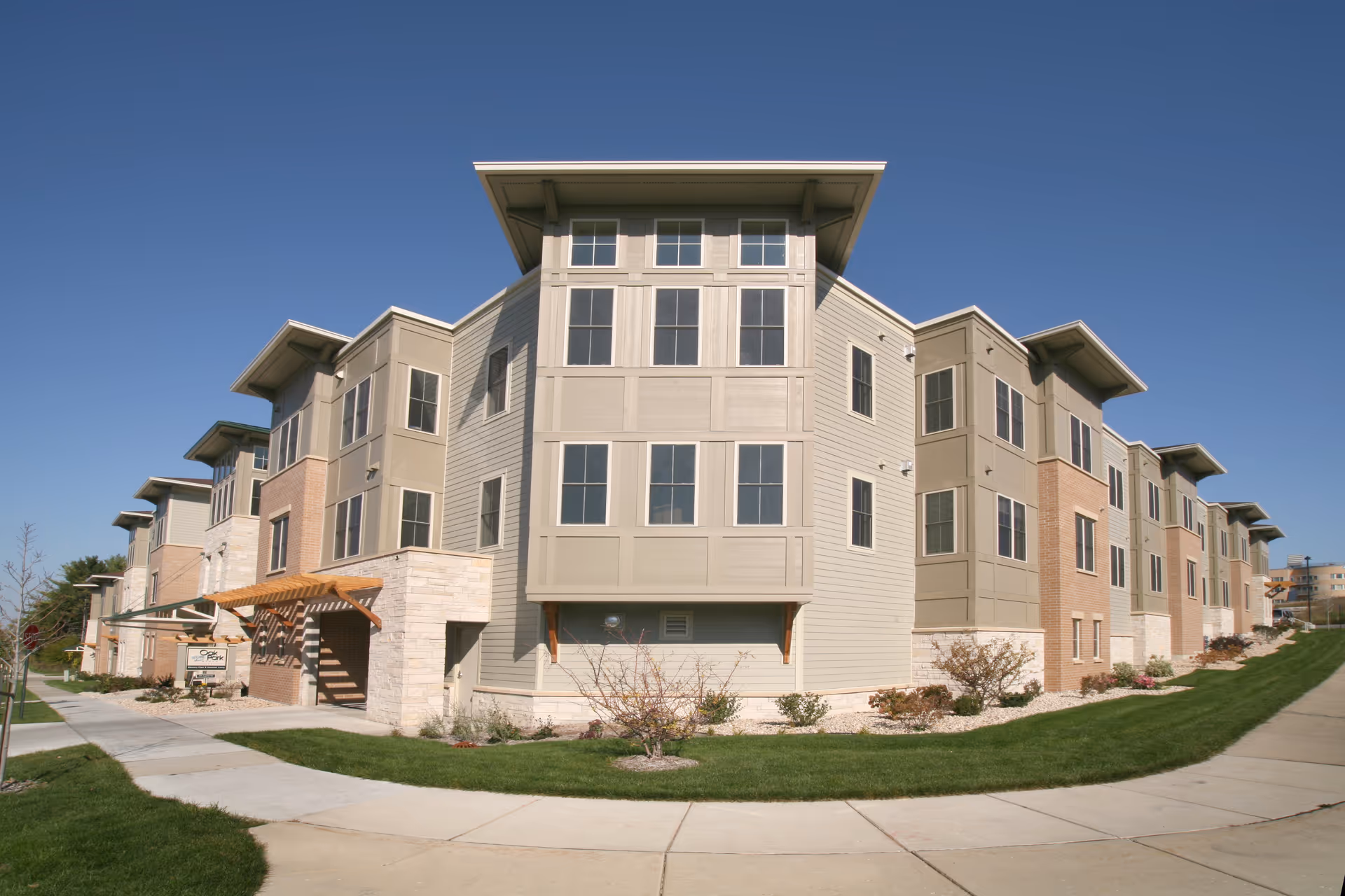 Exterior view of a modern multi-story senior living building with landscaped surroundings.