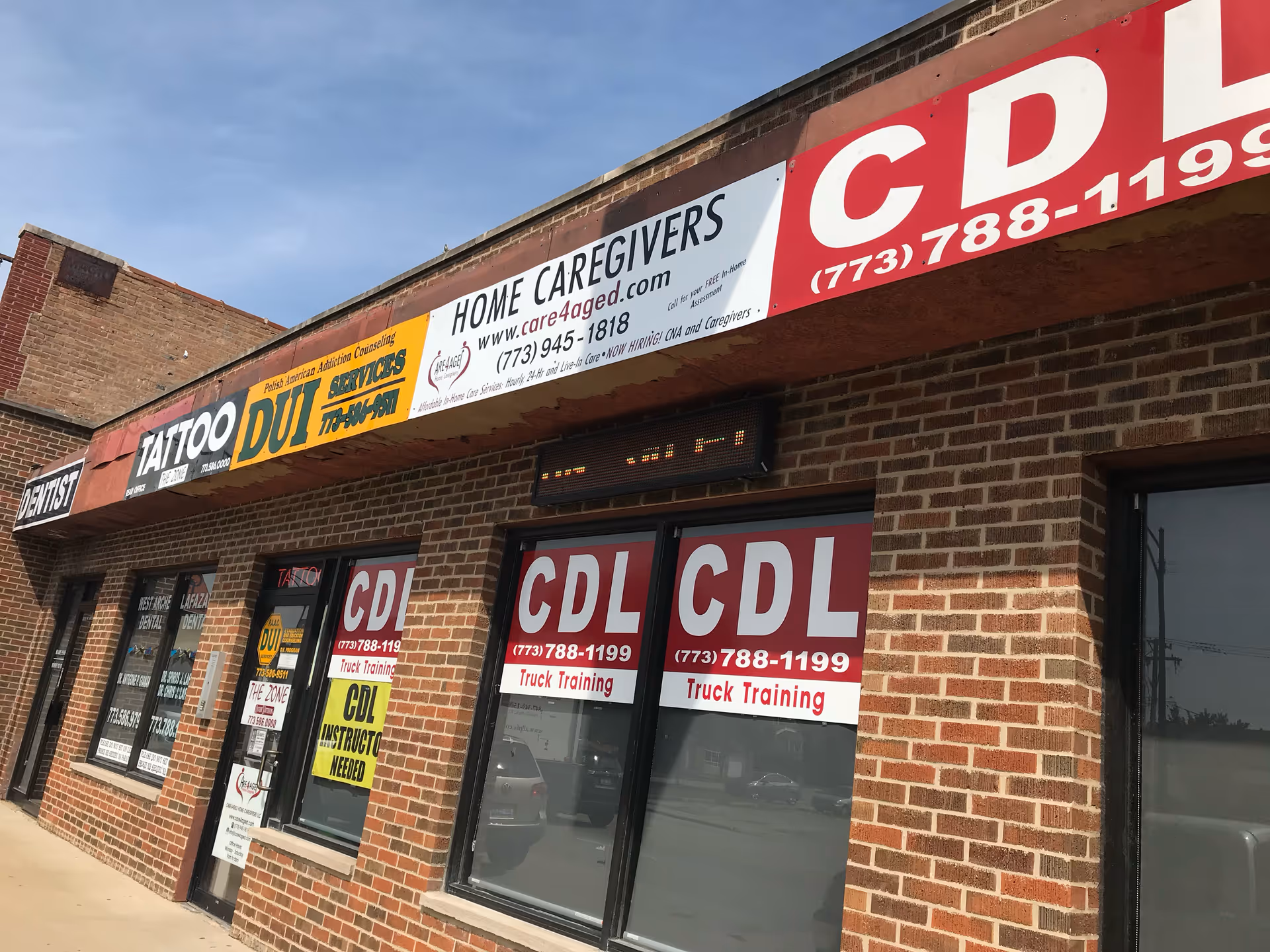 Brick storefront with signs including Home Caregivers and CDL advertisements.