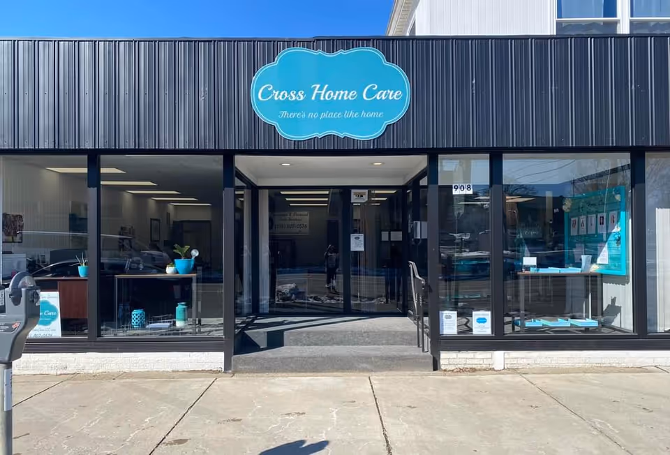 Exterior view of Cross Home Care storefront with glass doors and blue sign.