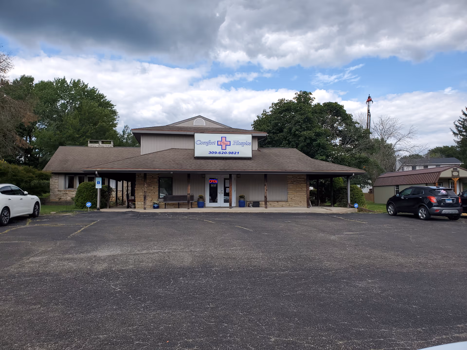 Front view of Comfort Plus Hospice, a single-story facility with sign and parking.