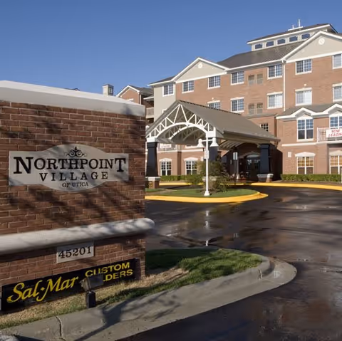 Exterior view of Northpoint Village of Utica with brick building and entrance canopy.