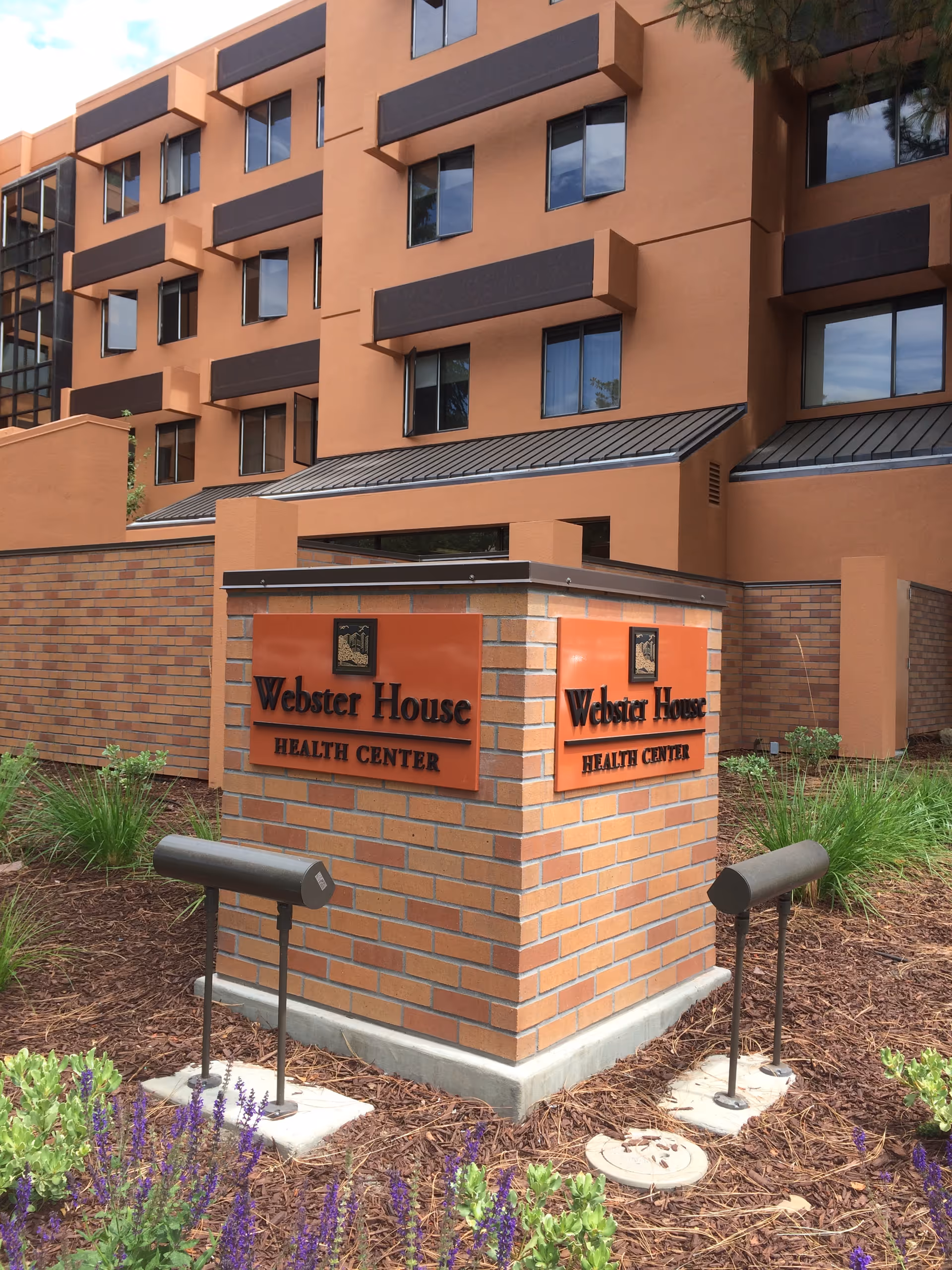 Front of a brick building with Webster House Health Center sign.