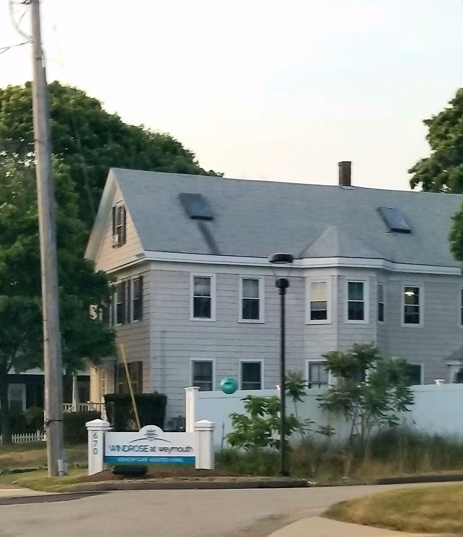 Exterior view of Windrose at Weymouth building with sign at the curb.