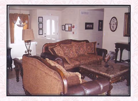 Cozy living room with brown couches, a coffee table, lamp, and wall decor.