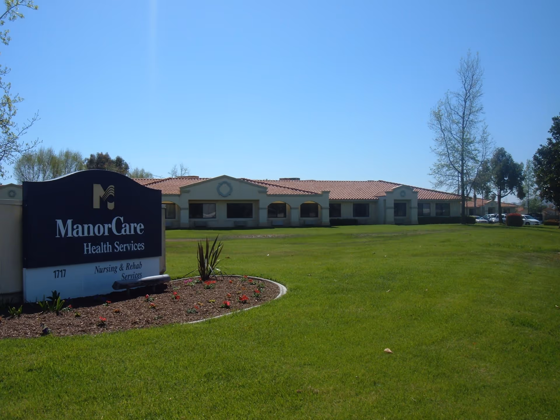 Exterior view of ManorCare Health Services Hemet with a large sign and green lawn.