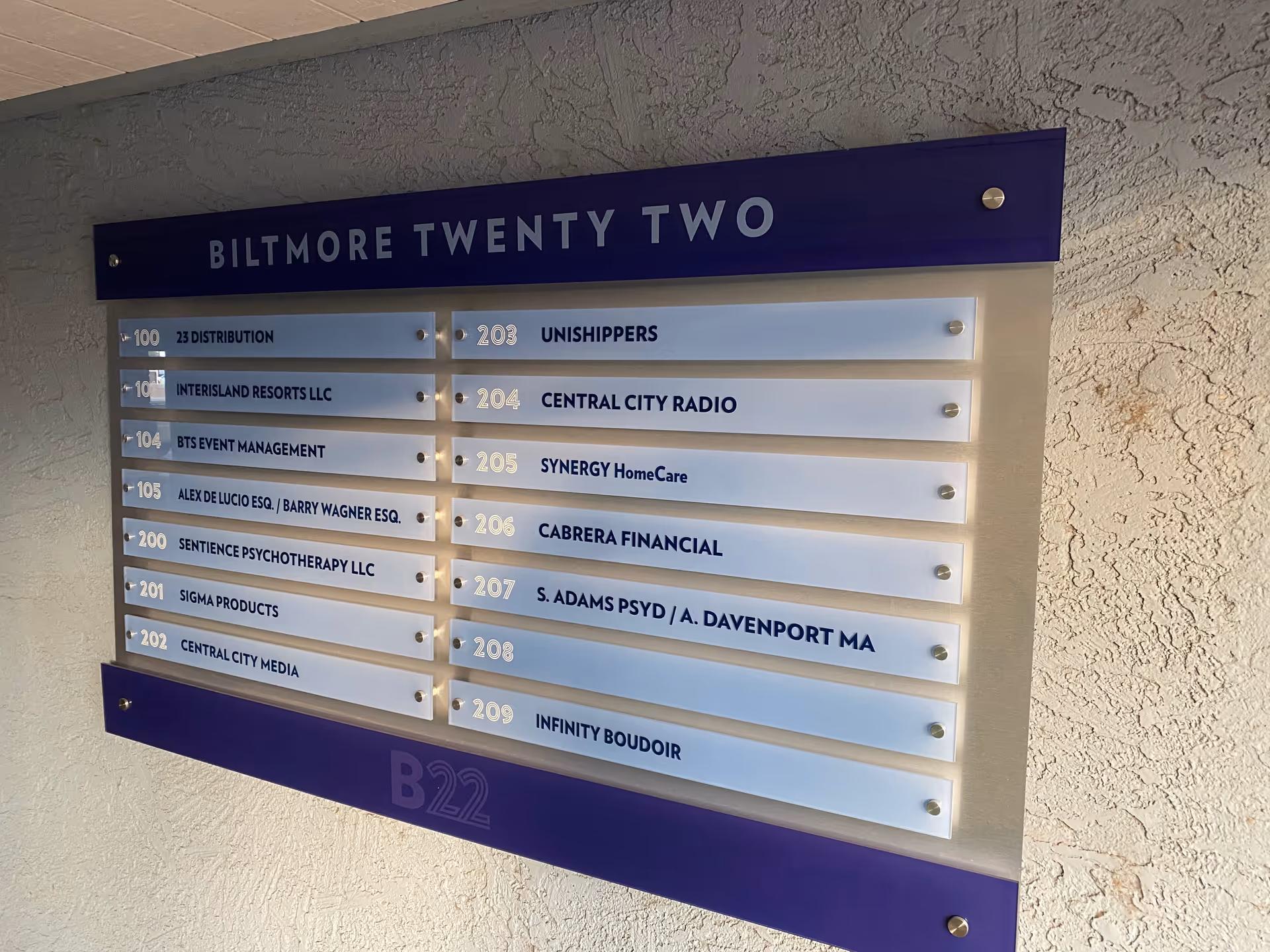 A blue and white directory plaque listing offices, including SYNERGY HomeCare.