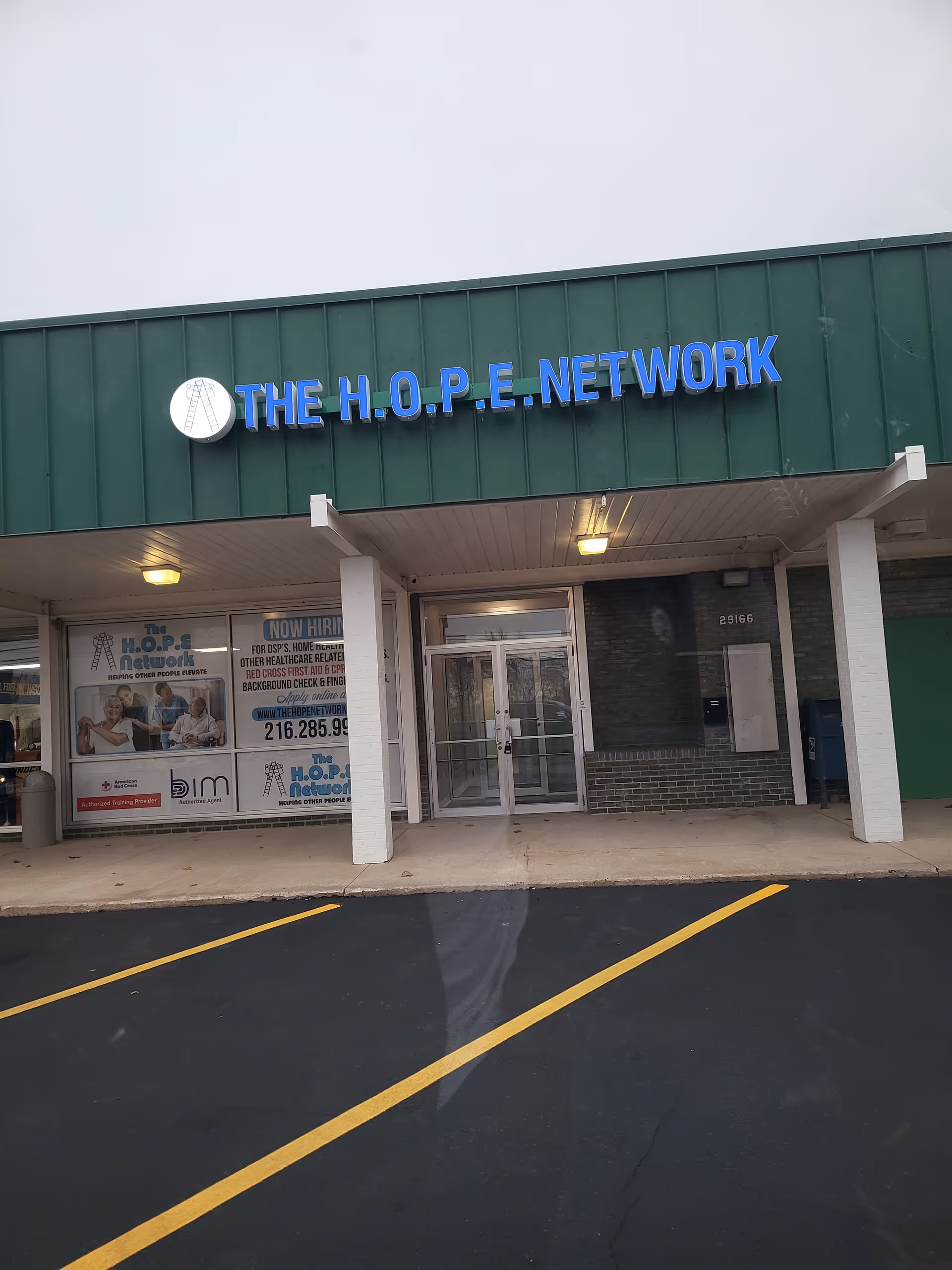 Exterior of a building storefront displaying The H.O.P.E. Network sign and glass doors.