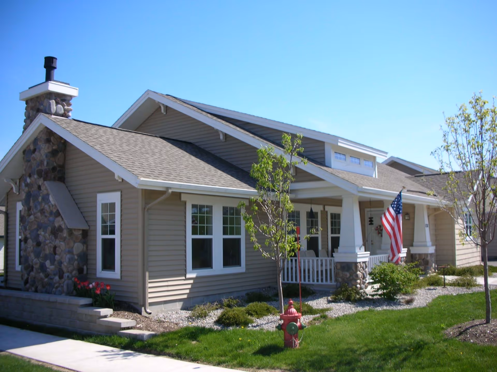 Exterior view of Cherry Ridge senior living facility, a building with a stone chimney and flag.