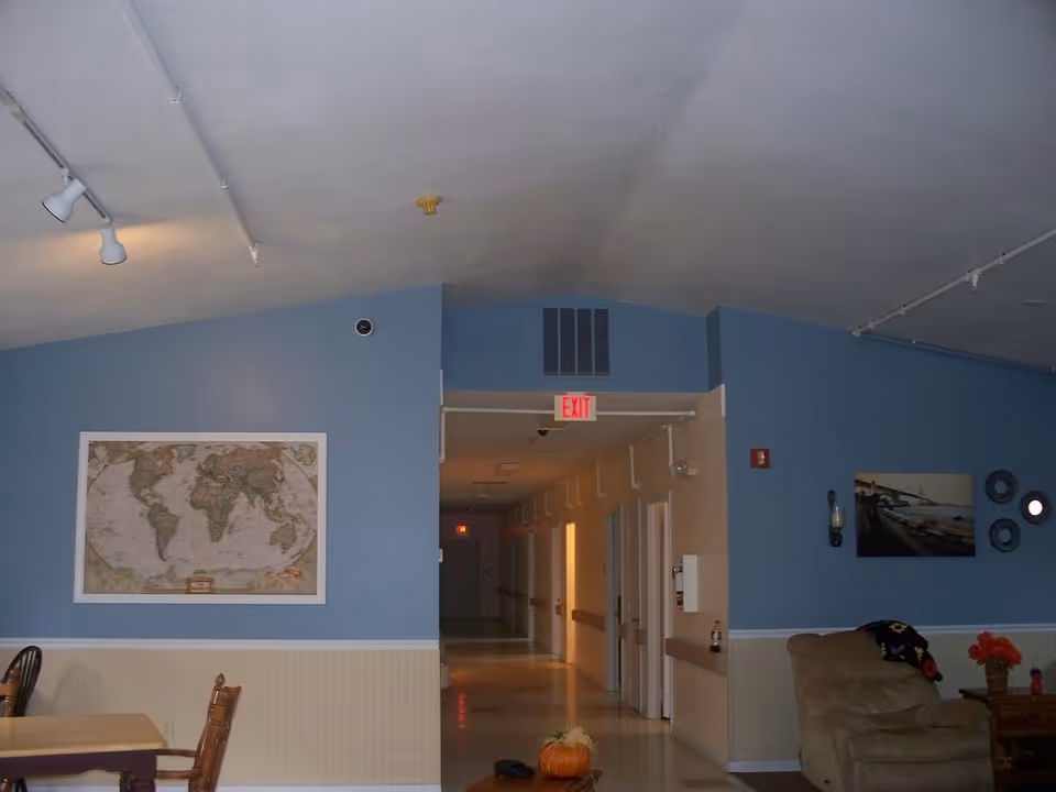 Interior hallway at Margaret's Meadows, blue walls, map on wall, right seating area.