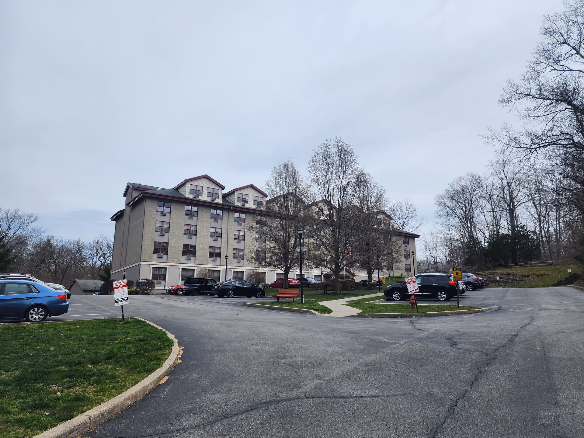 Exterior view of Heritage Pointe Apartments with a parking lot and leafless trees.