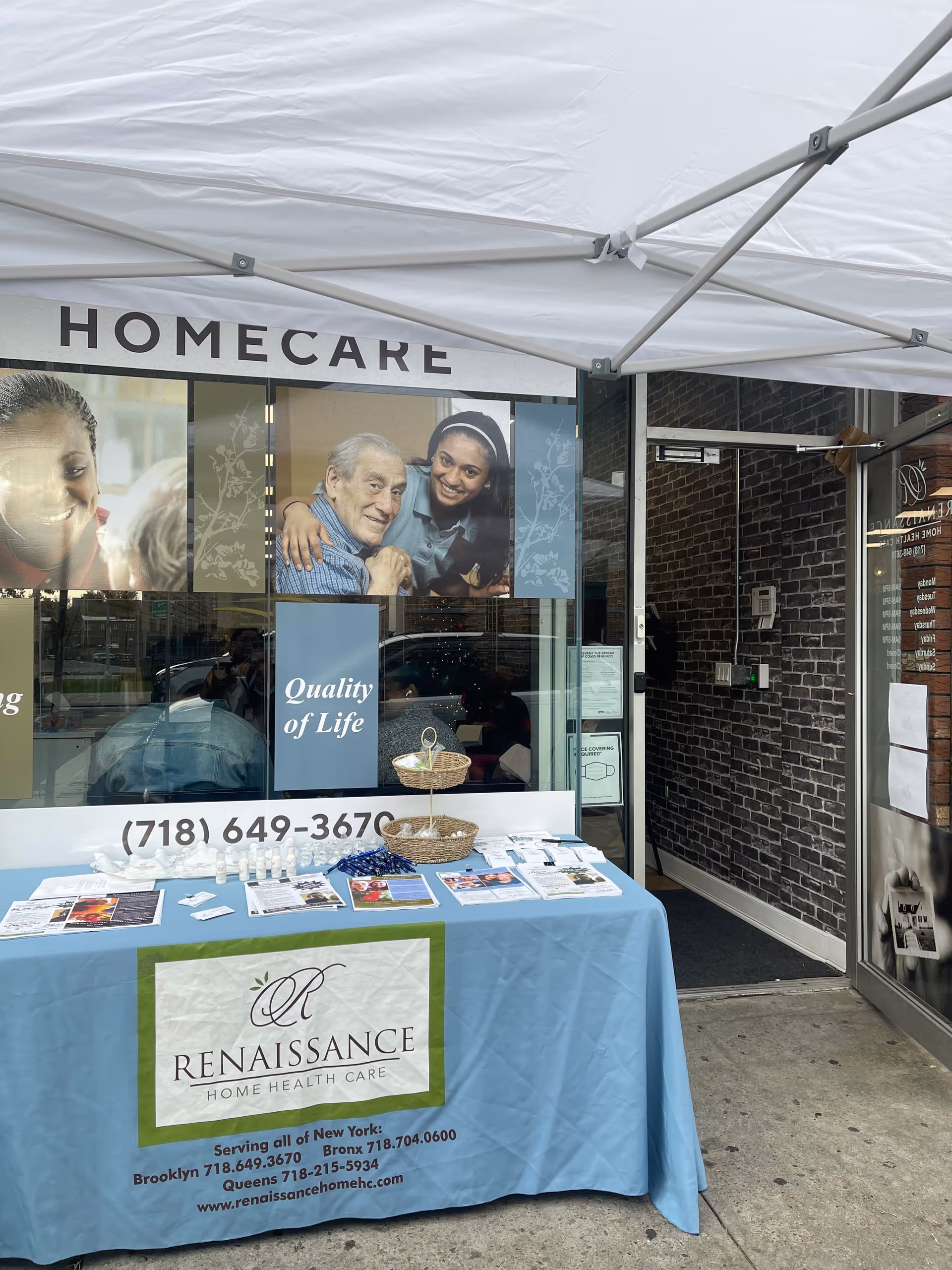 Outdoor information table outside Renaissance Home Health Care storefront under a tent.