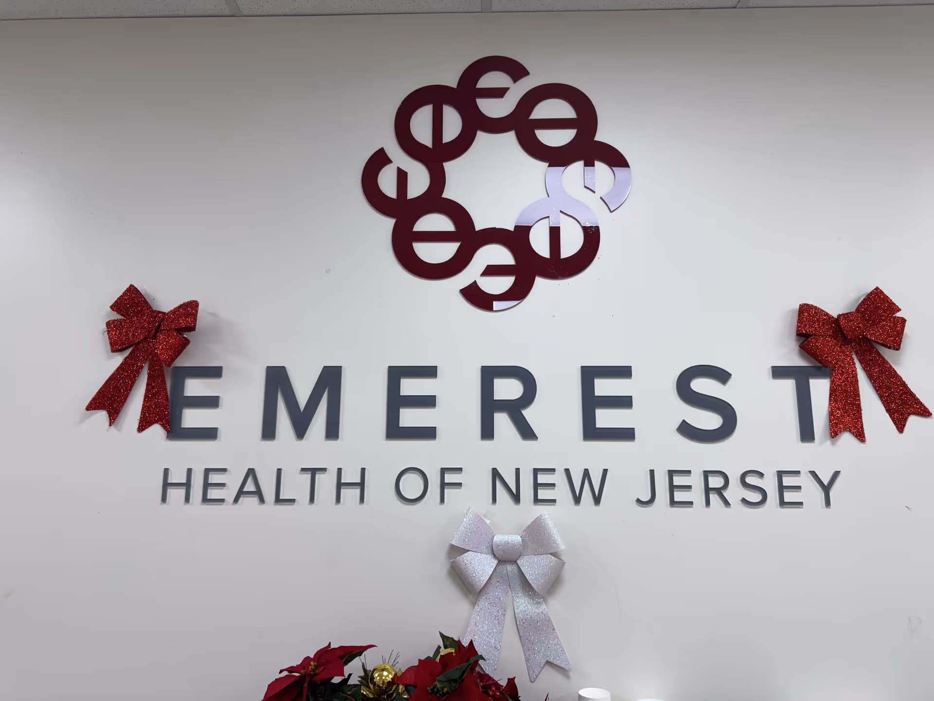 Interior wall with Emerest Health of New Jersey sign and holiday bows.