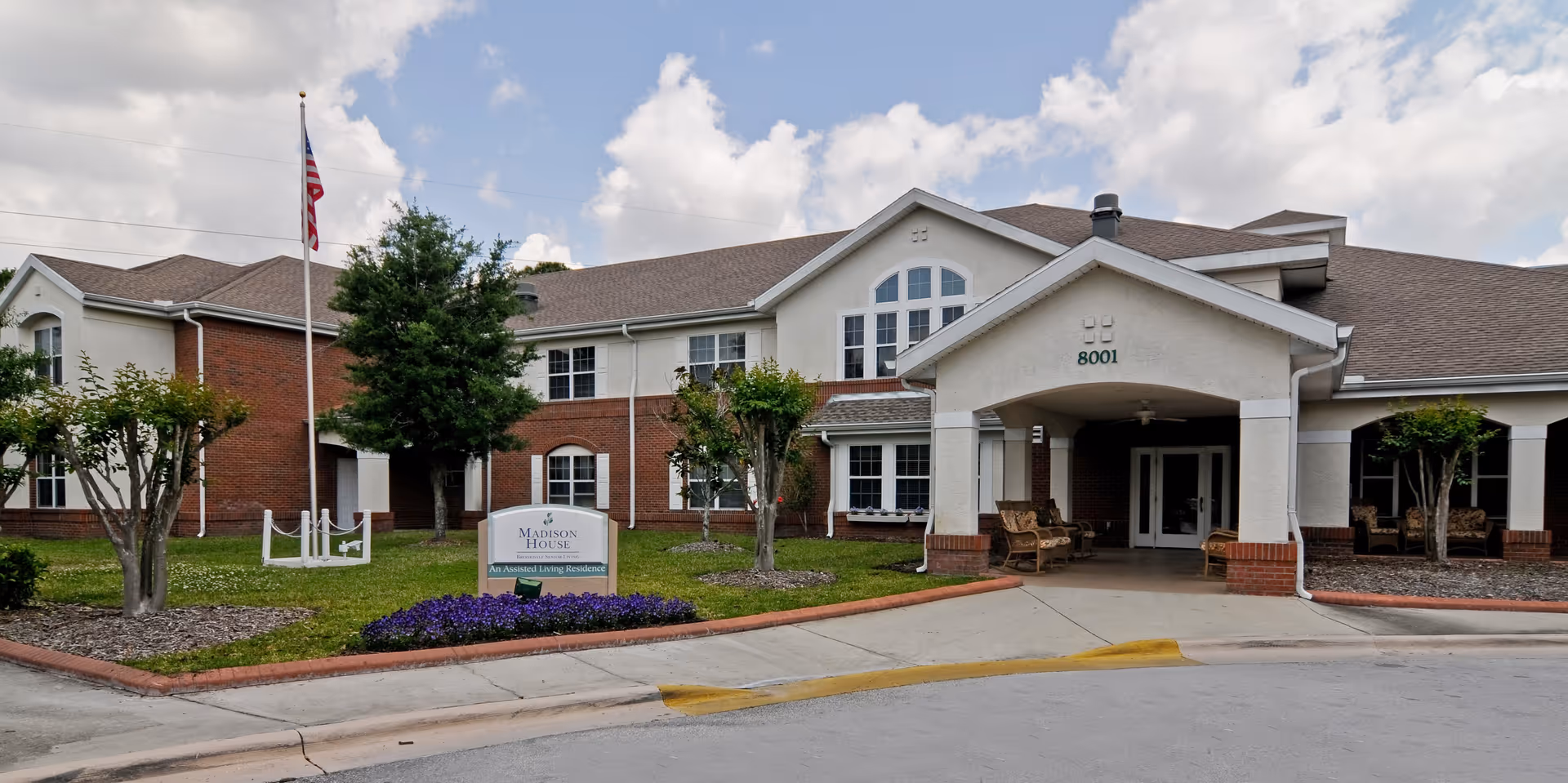 Exterior view of Brookdale Dr. Phillips senior living entrance with a covered portico and landscaping.