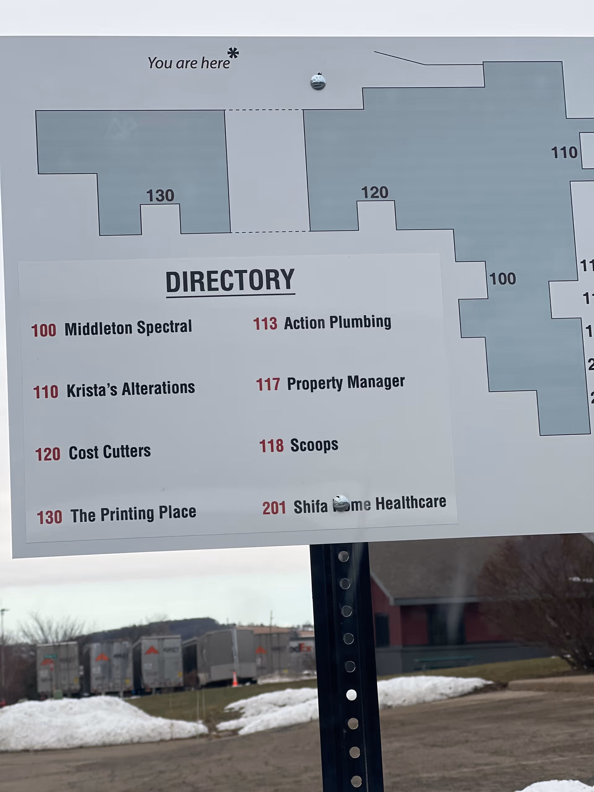 A directory sign outside a senior facility displaying unit numbers and a building map.
