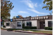 Exterior view of a single-story building with Alcott Rehabilitation Hospital signage.