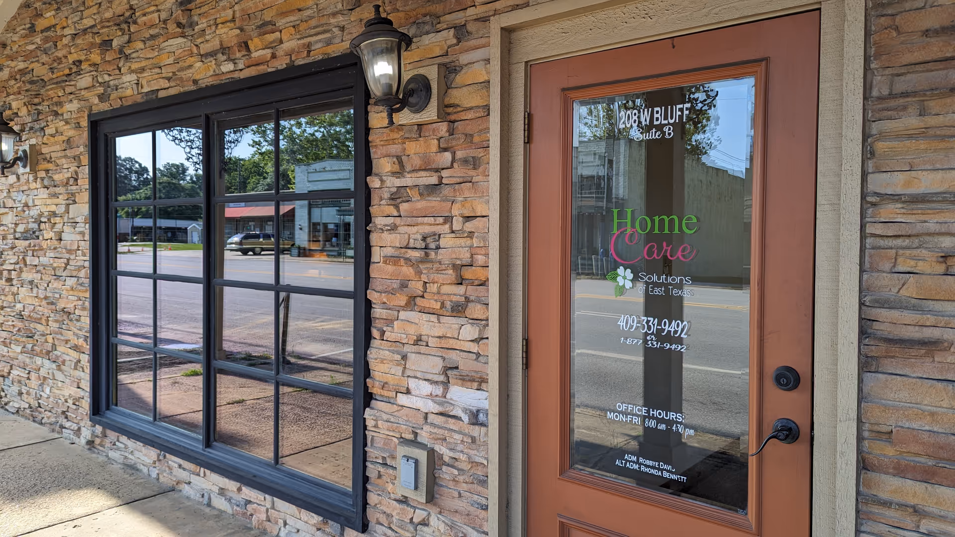 Stone facade, large window, and brown door advertising Home Care Solutions of East Texas.