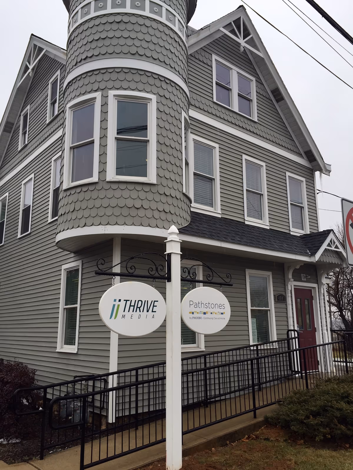 Gray turreted building exterior with Pathstones by Phoebe sign at entrance.