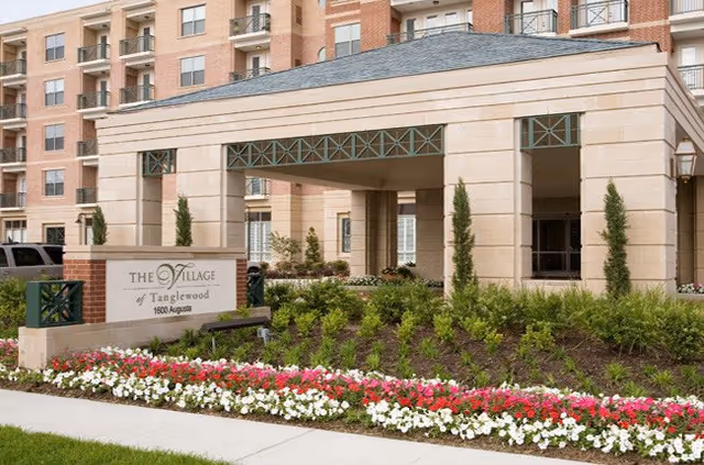 Exterior view of The Village of Tanglewood entrance with landscaping and a sign