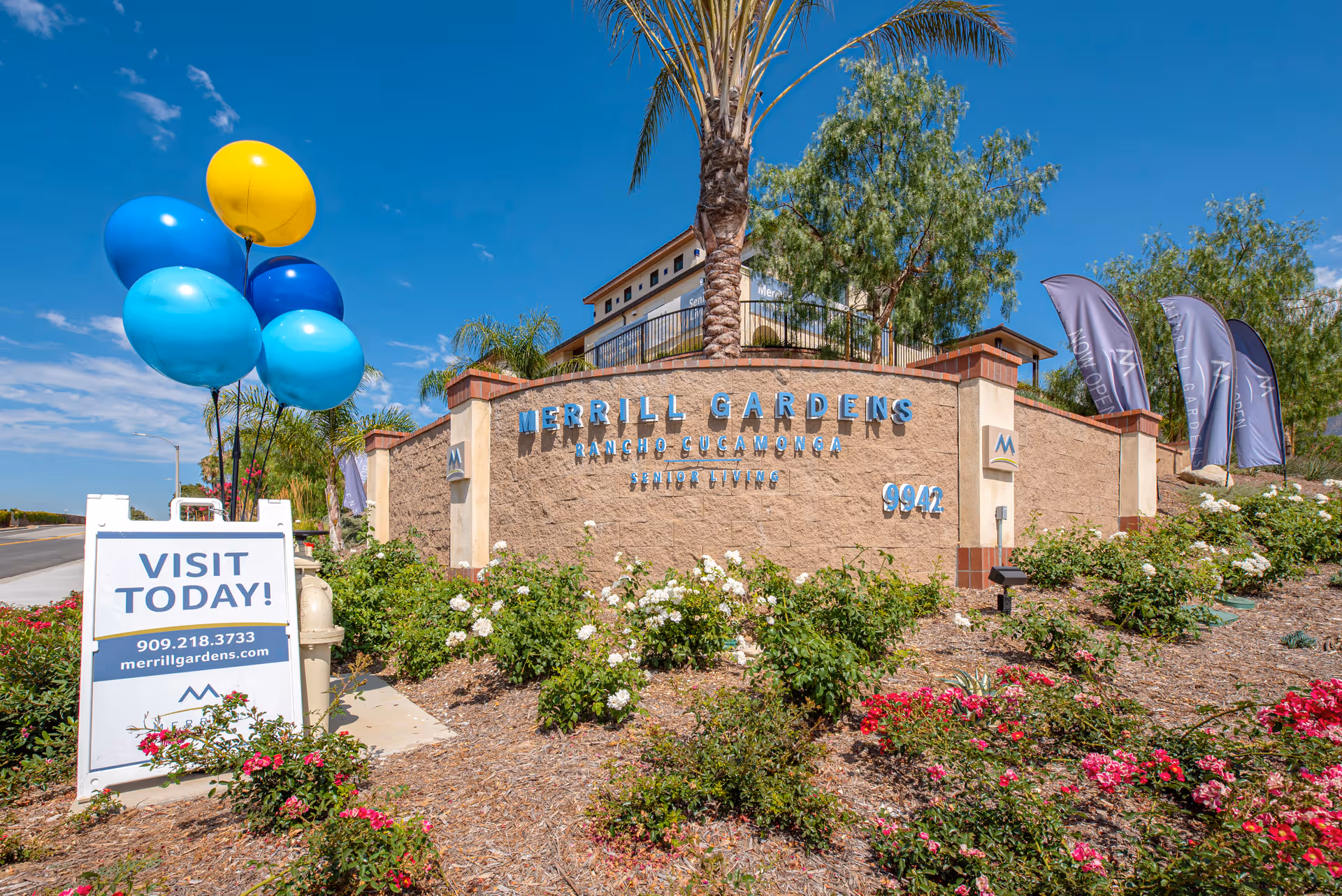 Exterior front entrance of Merrill Gardens at Rancho Cucamonga with balloons and flowers.