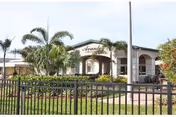 Exterior view of Avante at Melbourne with a gated entrance and palm trees.