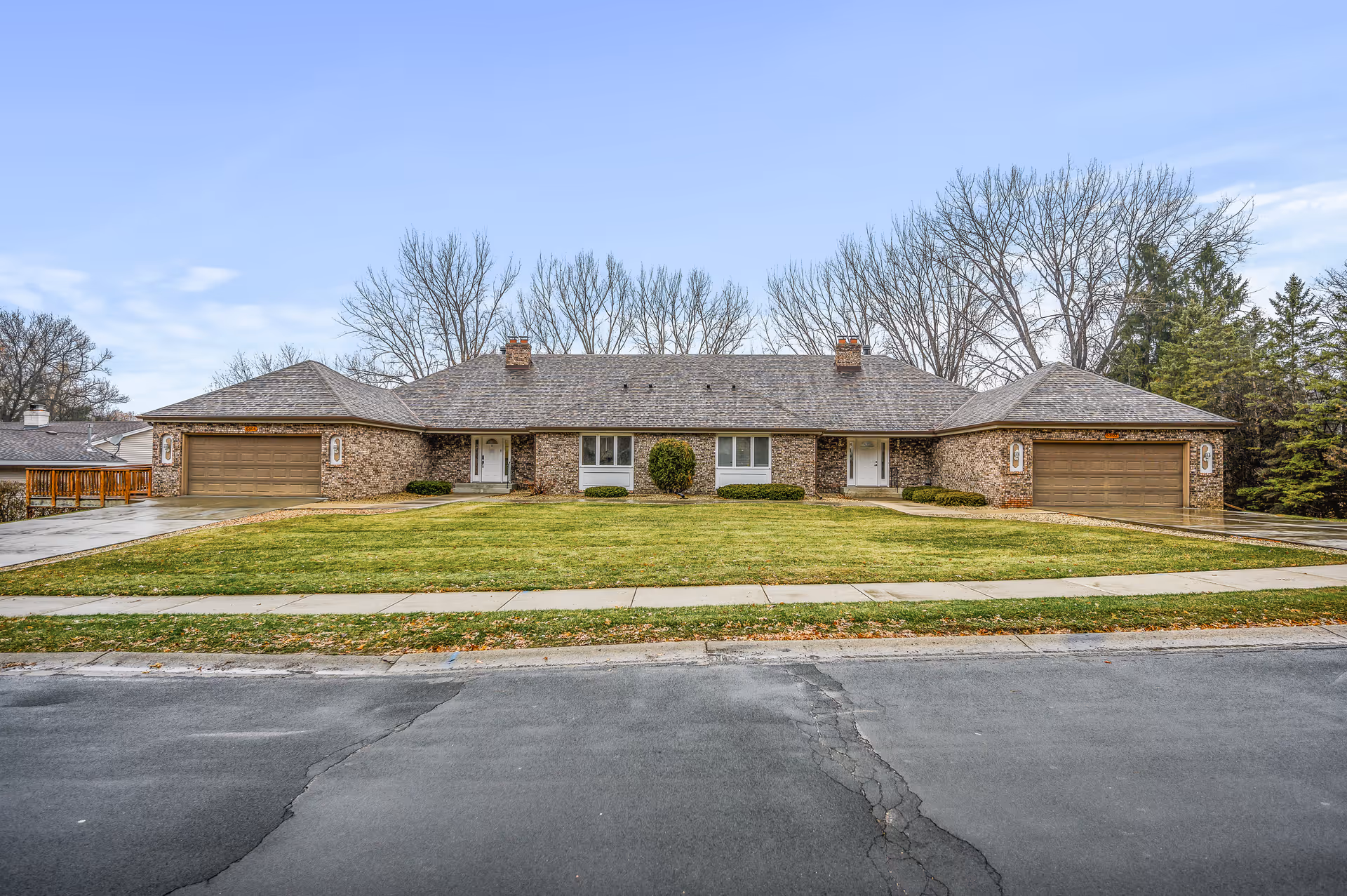 A single-story brick building with a front lawn and two garage doors facing the street.