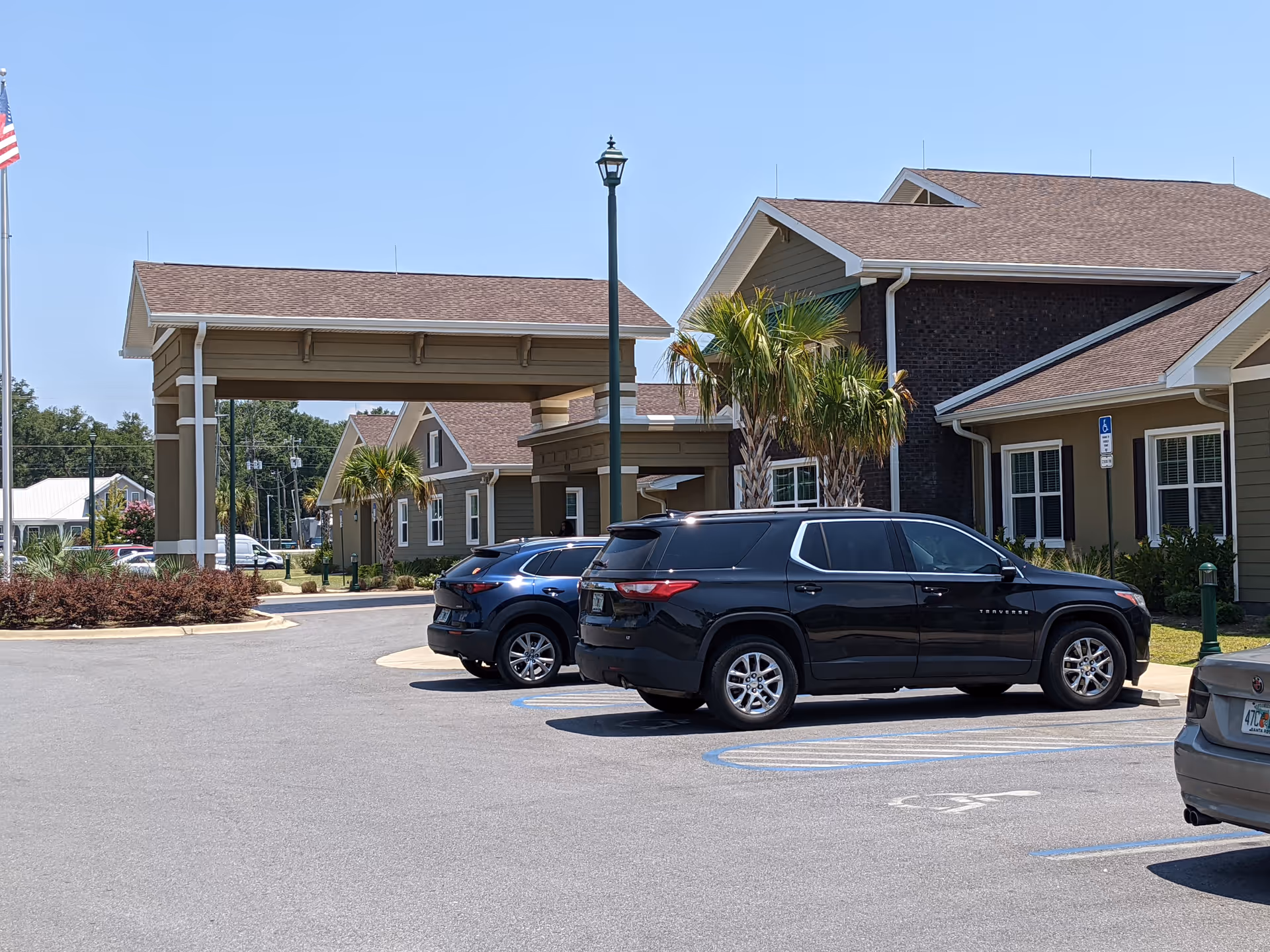 Exterior view of De Luna Health and Rehabilitation Center with parked cars by the entrance.