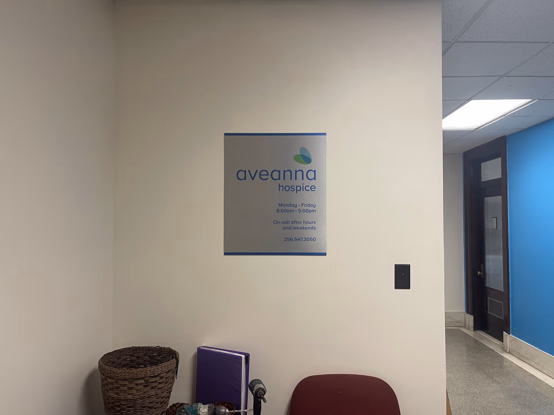Interior hallway with an Aveanna Hospice sign on a beige wall.