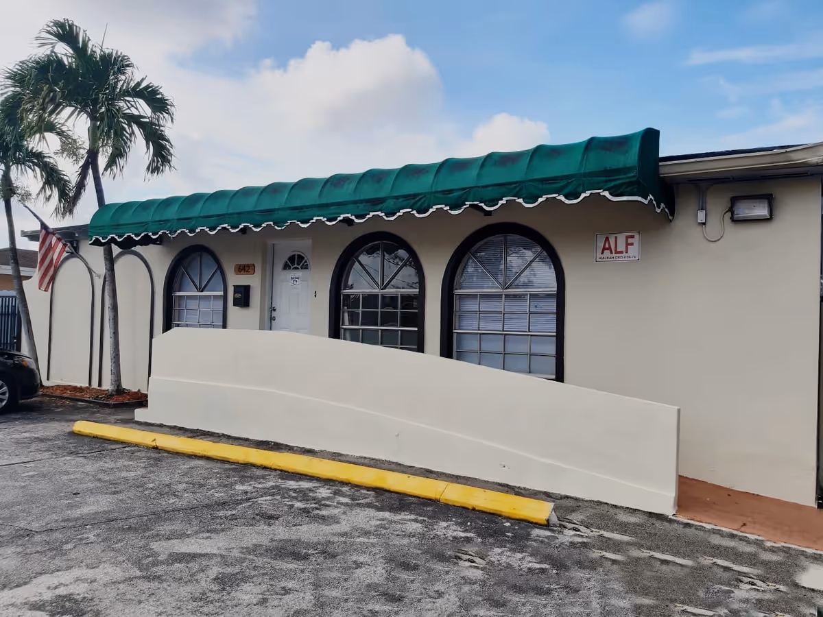 Exterior view of Care and Love Retirement Home with green awning and arched windows.