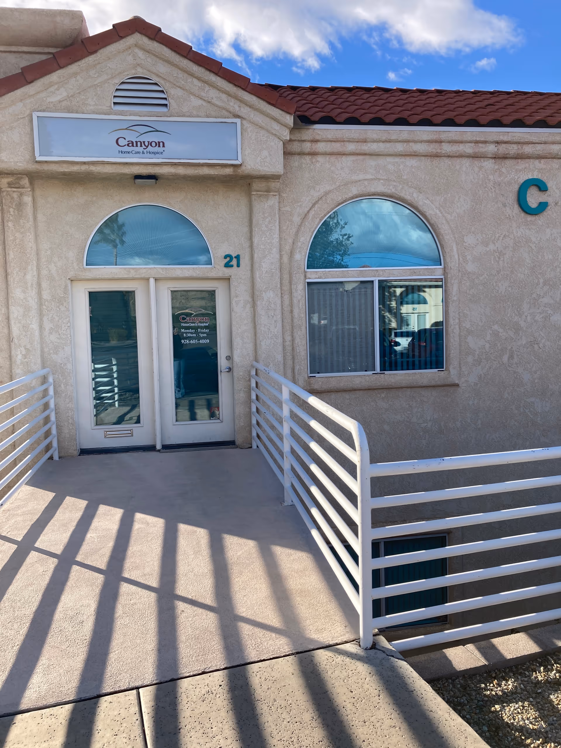 Front entrance of Canyon Home Care and Hospice building with ramp railing and arched windows.