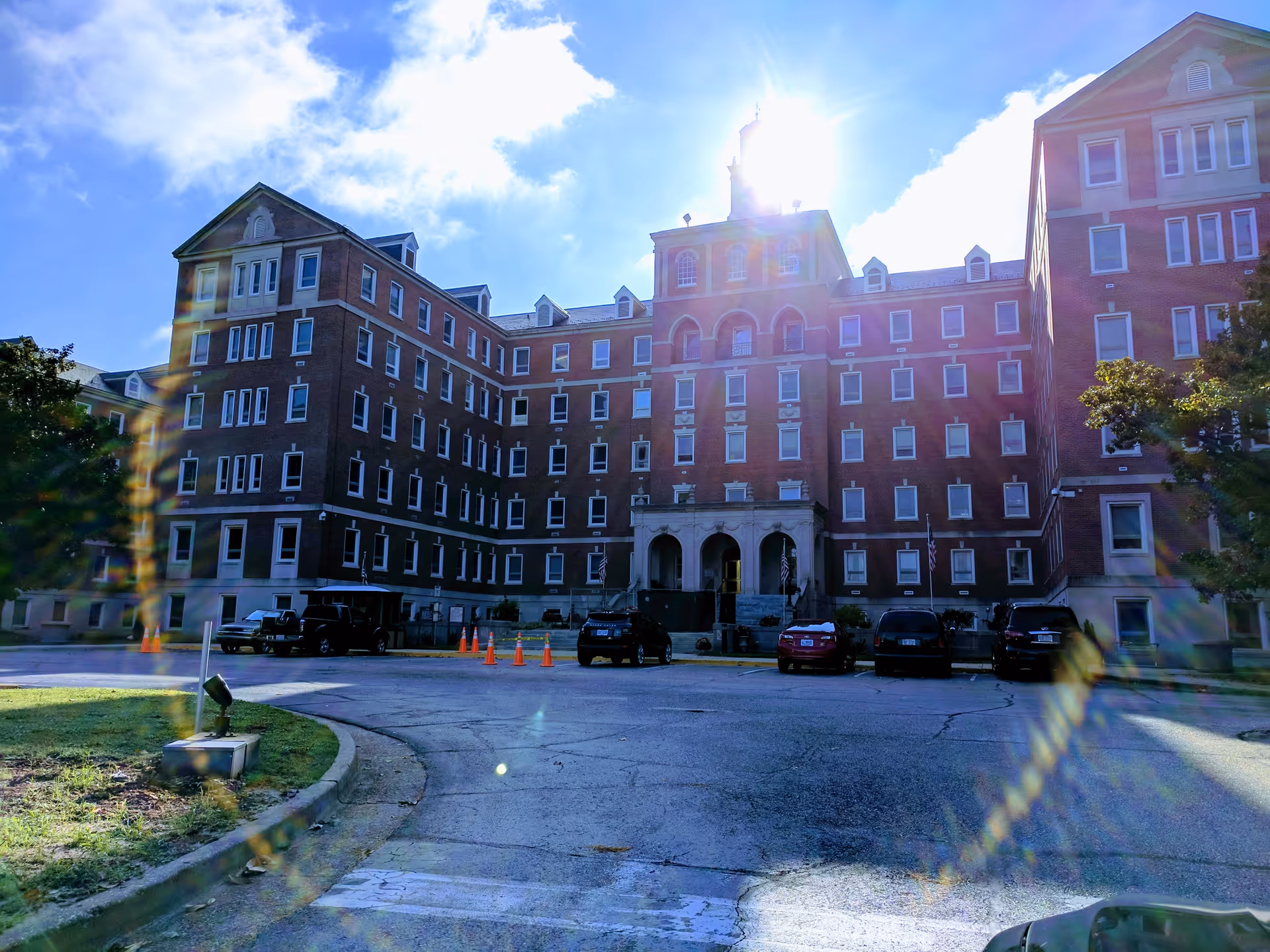 Front exterior view of Fayetteville VA Medical Center, a large brick hospital with parked cars.