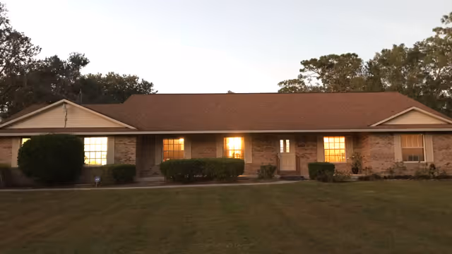 Front view of a single-story brick senior living facility at dusk.