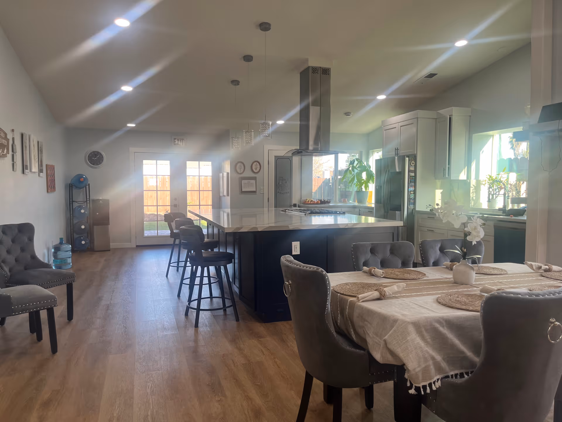 Open-concept kitchen and dining area with island, bar stools, and dining table.
