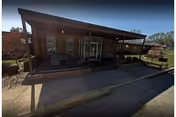 Front view of a single-story senior living facility with a covered entrance porch.