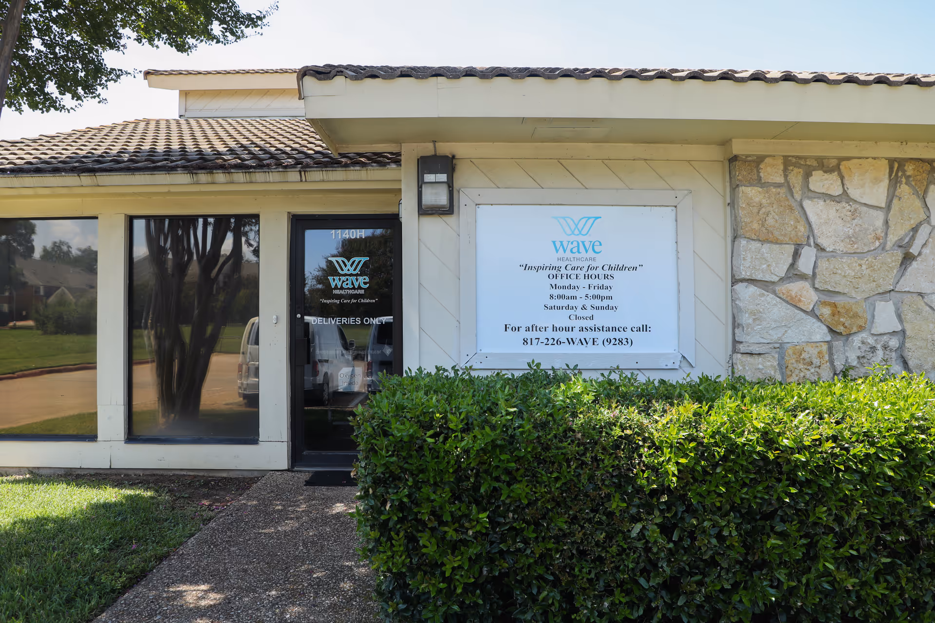 Exterior view of Wave Healthcare Arlington entrance with sign and hedge