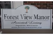 Front sign reading Forest View Manor Assisted Living outside a brick building.