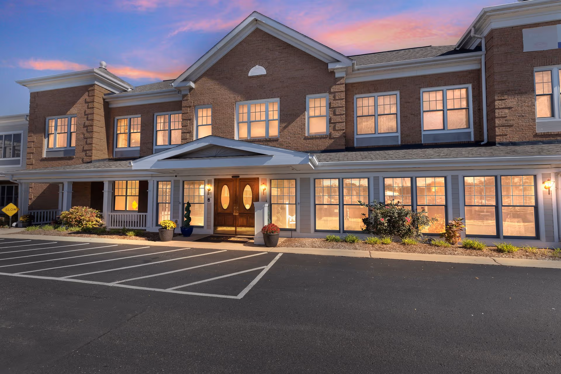 Exterior view of Sunrise on Vernier senior living facility with brick facade, large windows, main entrance.