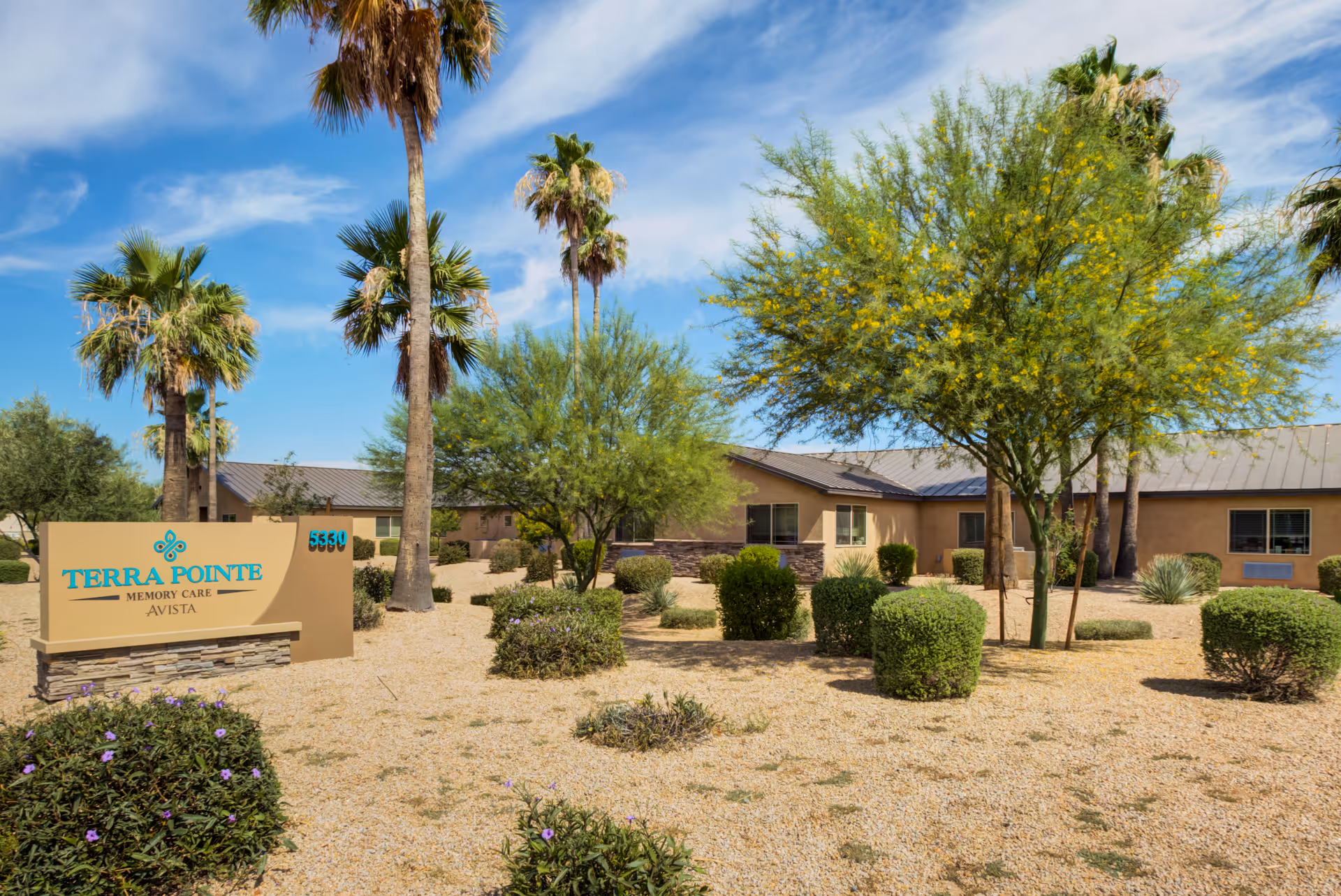 Desert landscaping frames the front of a single-story memory care facility with a Terra Pointe sign.