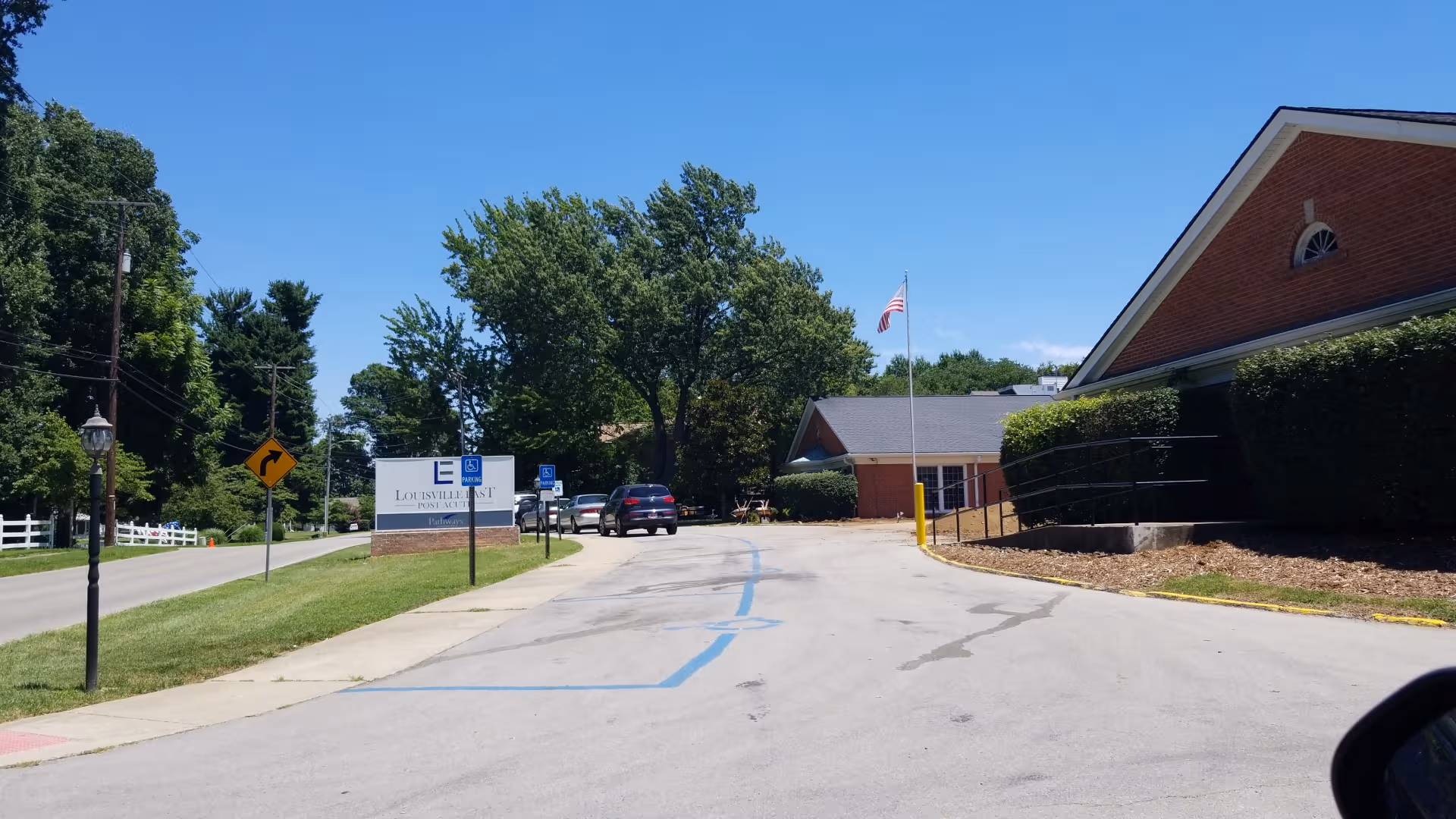 Exterior view of Louisville East Post Acute Care building with parking and trees.