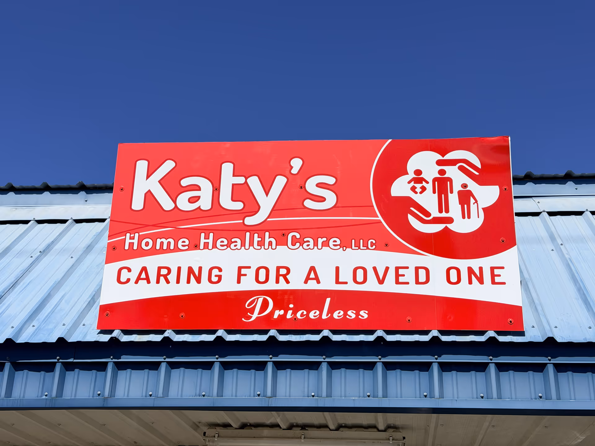 Red Katy's Home Health Care sign displayed on a blue metal building exterior.