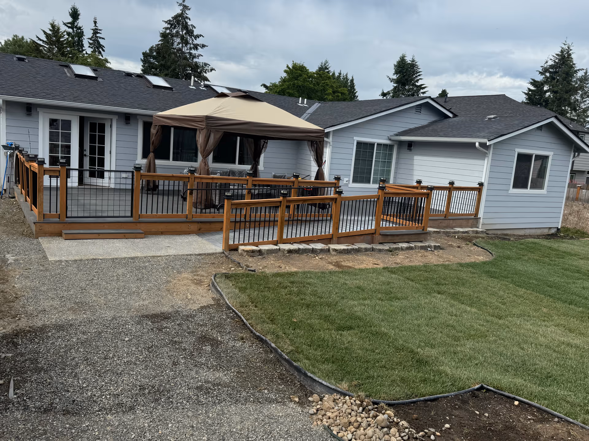 Gray single-story facility with a wooden deck, gazebo, and outdoor seating.