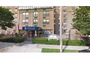 Exterior view of Throgs Neck Rehabilitation & Nursing Center entrance, a brick building with blue awning.